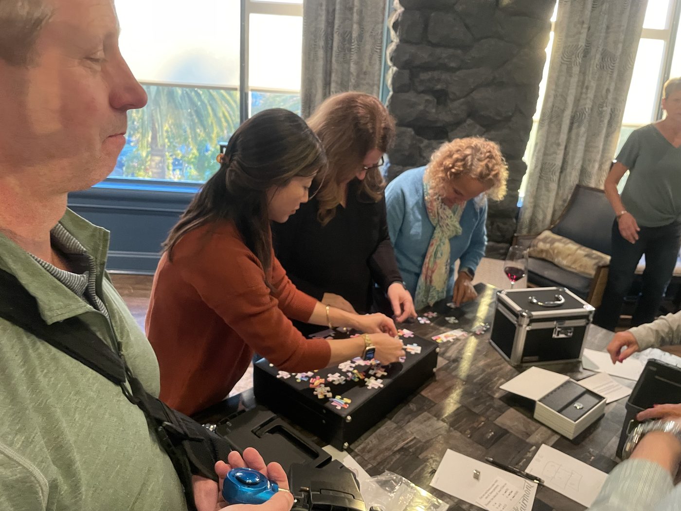 Teammates examine a portable puzzle case and work together on its locks